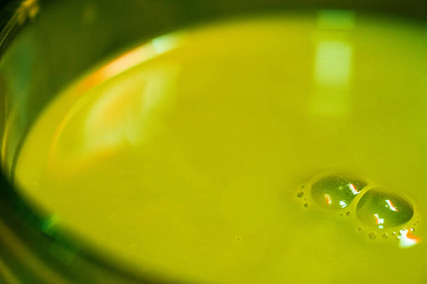 Close-up texture showing thin layers of matcha and milk blending naturally inside a transparent oz glass.