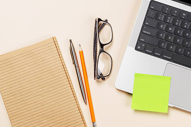 istock Blank notepad, laptop and stationery on beige workspace, top view with copy space 2246786084
