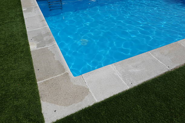 istock Corner of swimming pool with artificial grass and stone border 2246794077
