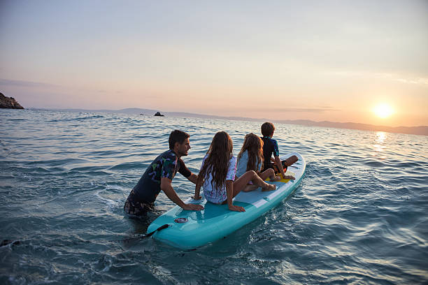 istock Family enjoying paddleboard ride together during sunset 2246799766