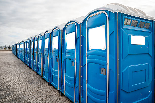 istock Panoramic view of numerous blue portable public toilets lined up. 2246801659