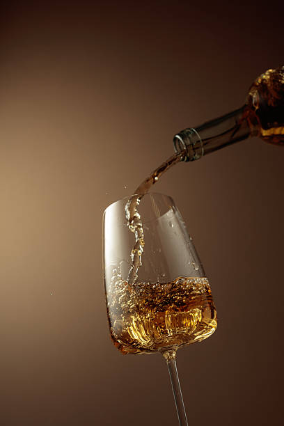 istock Pouring white wine from a bottle into a glass. 2246803495