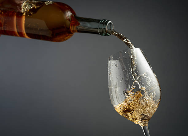 istock Pouring white wine from a bottle into a glass. 2246803510