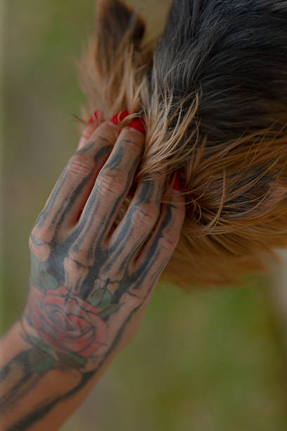 A Beautiful Artistic Hand Covered in Tattoos Gently Touching Hair
