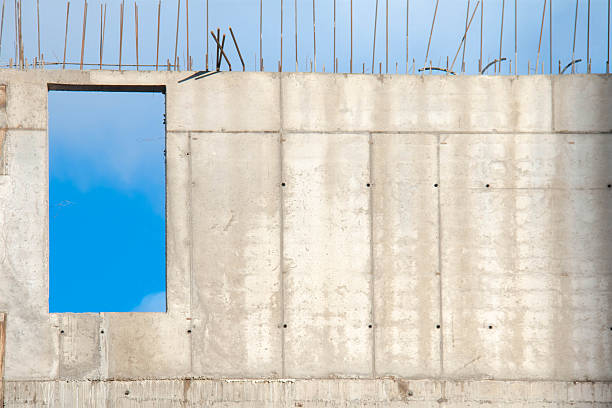 Concrete Wall Frame of Building under Construction. Formwork Prints on Surface with Fittings Release from Monolithic box, with window hole at Construction Site. Architectural origin of Structure