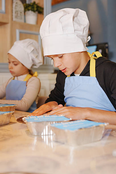 istock Kids enjoy cake decorating activity in a cozy kitchen 2246804661