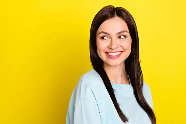 istock Photo of adorable shiny woman dressed blue pullover smiling looking back empty space isolated yellow color background 2246808799