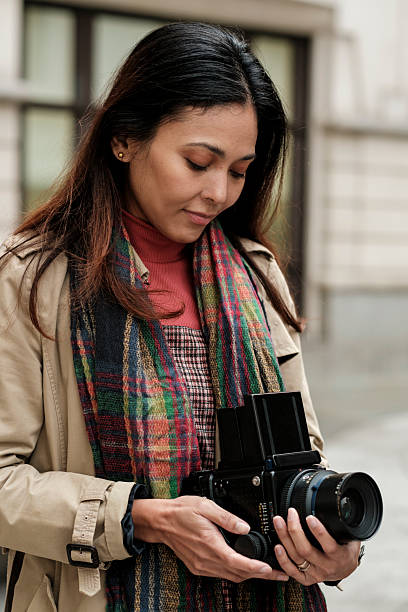 istock Woman holding medium format film camera outdoors 2246816422