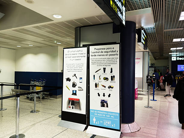 Manchester, UK - October 04, 2025: Instructional posters guide travelers through security procedures in a modern Manchester airport terminal.