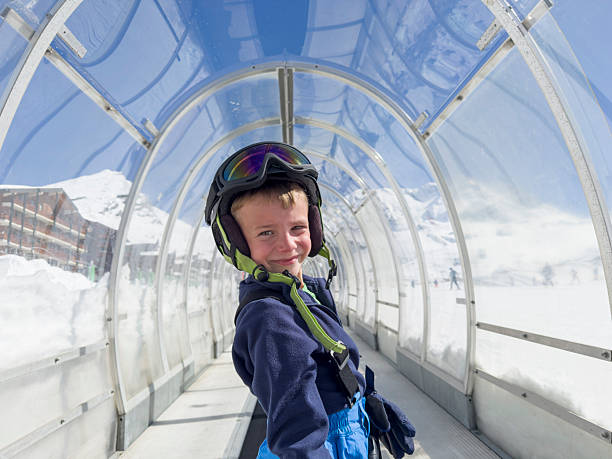 Boy in travelator at ski resort, Val Thorens