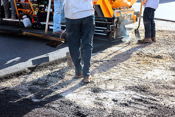 istock Road construction workers laying asphalt on busy street 2246826496