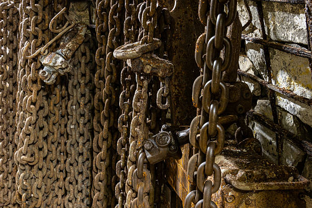 istock Heavy chains, hooks, air hoses, and cables on the floor of a dim coal mine. 2246828761