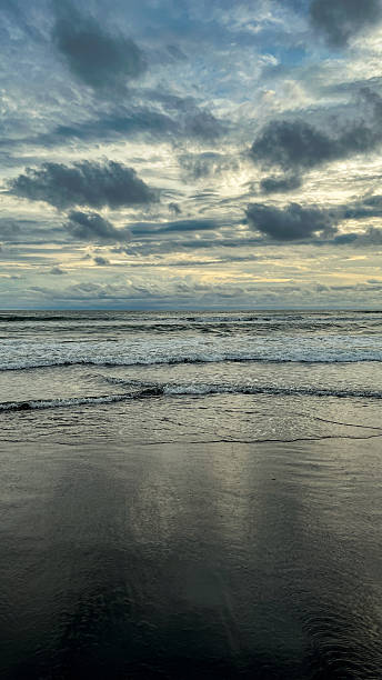 istock ocean waves rolling toward a dark sandy shoreline under a cloudy sky. natural coastal scenery with textured water, soft light, and a calm atmospheric mood 2246832927