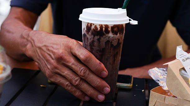 Close-up of a man's hand holding a glass of drink.