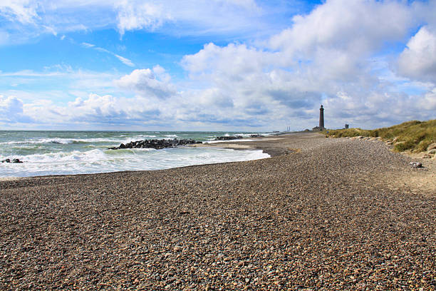 Rubjerg Knude Fyr lighthouse on the Rubjerg Knude shifting sand dune on the coast of North Jutland, Denmark, glows in the evening sun