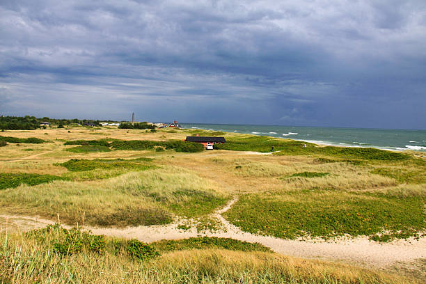 istock Skagen, Denmark, 18-08-2013 Description:  Isolated Red and Black House on Dramatic Coastal Dunes 2246839388