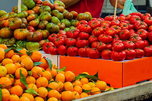Vibrant Fresh Market Tomatoes And Oranges Display At Colorful Outdoor Produce Stand