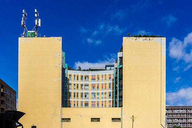 istock Yellow Building With Curved Center Facade And Rooftop Antennas Under Bright Blue Sky 2246845815
