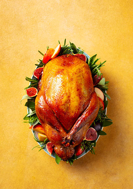 Whole Roast Turkey on a table. Light yellow background. Top view.