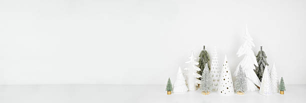 istock Green and white Christmas tree decor on a white shelf against a white wall banner background 2246852822