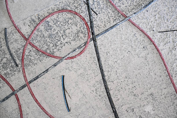 istock Red and black cables on bare concrete floor, closeup detail from above during electrical wiring installation in new house 2246852881