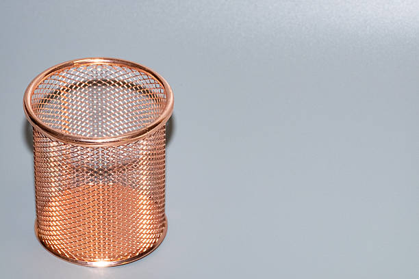 istock Copper wire mesh pencil holder on a smooth gray surface, showcasing intricate design and craftsmanship, ideal for organizing office supplies and enhancing workspace aesthetics 2246854730
