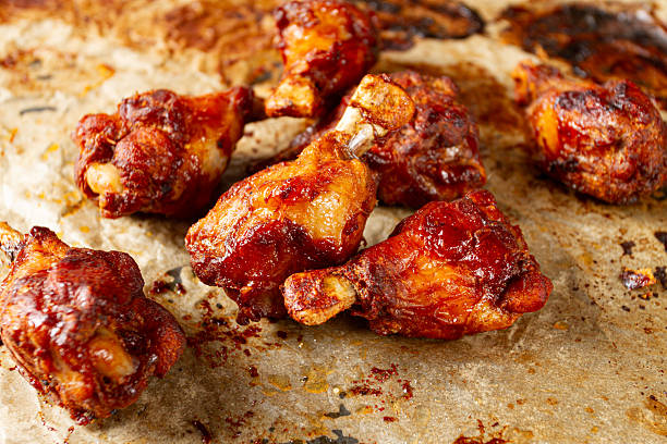 istock Grilled chicken legs lined with parchment paper and covered with caramelized glaze, close-up, 2246854739