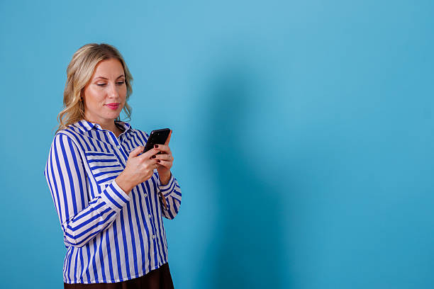 istock Woman scrolling smartphone, communicating and connecting online on blue background with copy space 2246857153