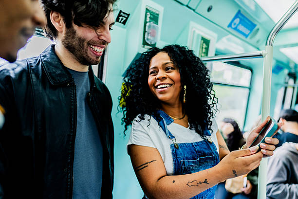 istock Excited friends talking and using mobile phone inside of subway train 2246862283