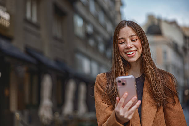istock Woman walking on the sidewalk at urban setting and talking on the phone 2246862607