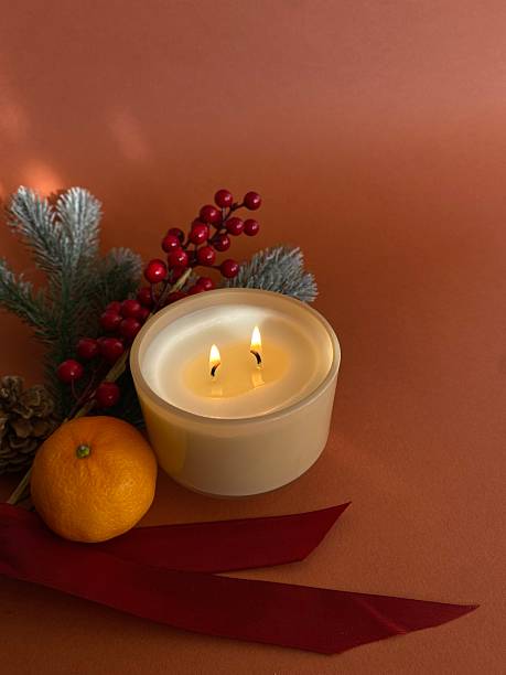 istock Fir branches, tangerine, lit candle and pine cones, arranged together, creating a warm and cozy atmosphere of the New Year holiday on a dark brown background 2246864423