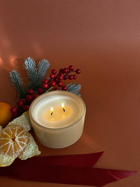 istock Fir branches, tangerine, lit candle and pine cones, arranged together, creating a warm and cozy atmosphere of the New Year holiday on a dark brown background 2246864427