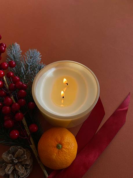 istock Fir branches, tangerine, lit candle and pine cones, arranged together, creating a warm and cozy atmosphere of the New Year holiday on a dark brown background 2246864432
