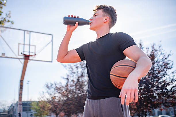 istock Energetic Young Man Drinking Water After Basketball Workout Outdoors on a Sunny Day 2246870661
