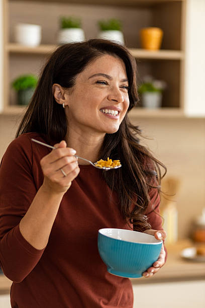 istock Young woman smiling wide while eating cereal 2246872091