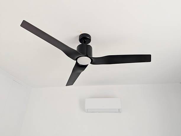 istock Modern black ceiling fan against bright white interior – home cooling concept 2246872269