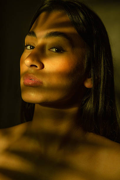 istock Woman with dramatic shadow and golden light on face 2246876702
