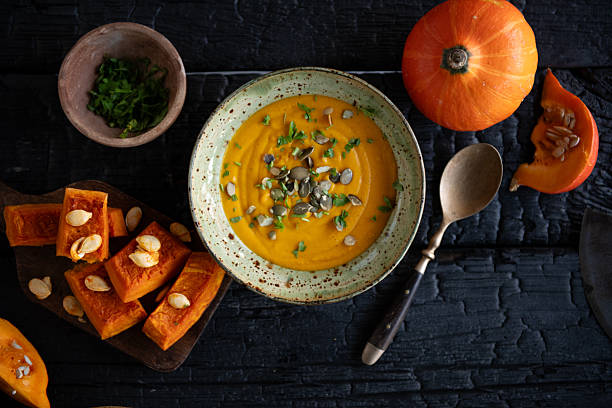 istock Rustic Pumpkin Soup with Fresh Squash on Dark Black Wooden Background Overhead 2246877852