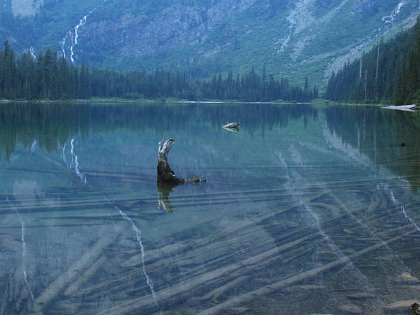 Smoke Hazed Mountains Reflect In The Calm Waters of Bowman Lake in Glacier National Park