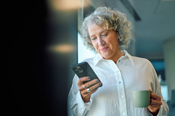 istock Mature businesswoman using smartphone having coffee break 2246881975