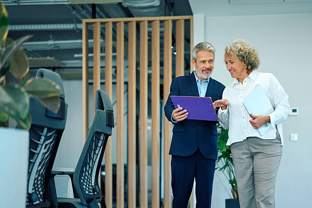 istock Mature business professionals discussing document in modern office 2246882011