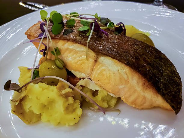 istock Salmon Steak fried to perfection on mashed potatoes and other vegetable garnishes 2246883062