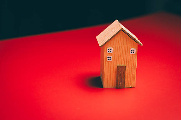 Wooden house on red background, home security awareness, stability reflection, financial planning support, emotional comfort insight, property value and safe housing concept