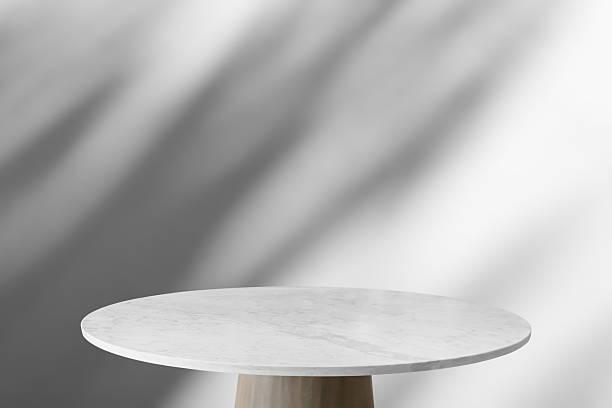 istock Round marble table top with tree leaves shadow drop on white wall background for mockup product display 2246884703