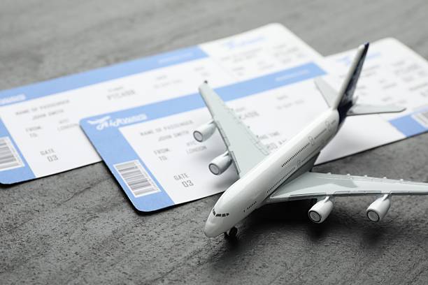 istock Travel agency. Flight tickets and plane model on dark textured table, closeup 2246892820