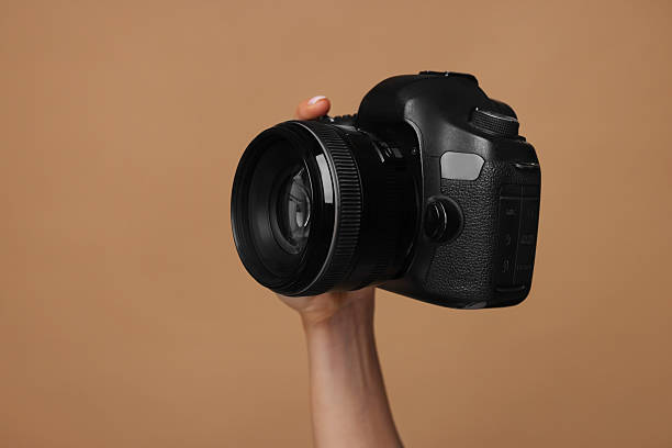 istock Photographer with camera on brown background, closeup. Space for text 2246893202