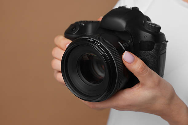 istock Photographer with camera on brown background, closeup 2246893205