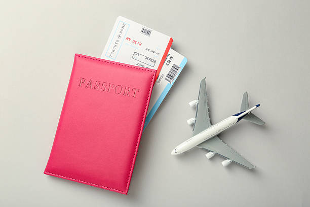 istock Passport with tickets and plane model on light background, top view 2246897112