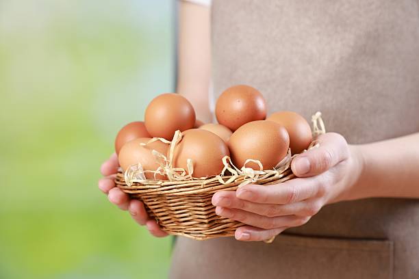 istock Woman with basket of eggs on blurred background, closeup. Space for text 2246897247