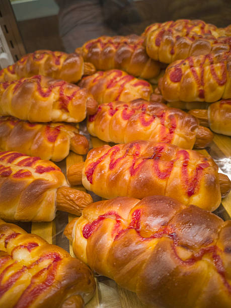 Close-up view of some sausage rolls, topped with ketchup and mayonnaise, fresh out of the oven in a bakery at a shopping mall